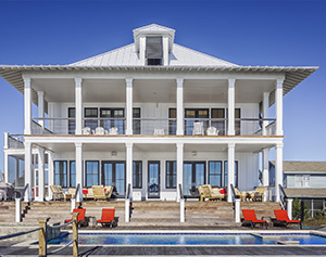 High-end homes for sale in Brick NJ like this white 2-story home with a pool and extensive patio and decks are a big draw for many