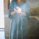Person in blue dress clapping hands in a cloud of dust indicating the need for duct service in Ocean County