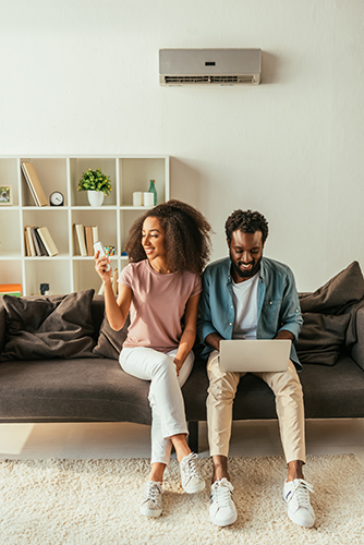 Couple relaxing on their couch after air conditioner repair in Mantoloking