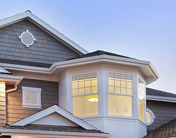 Large bay window on a grey home; Windows can have a big impact on air conditioner in Mantoloking